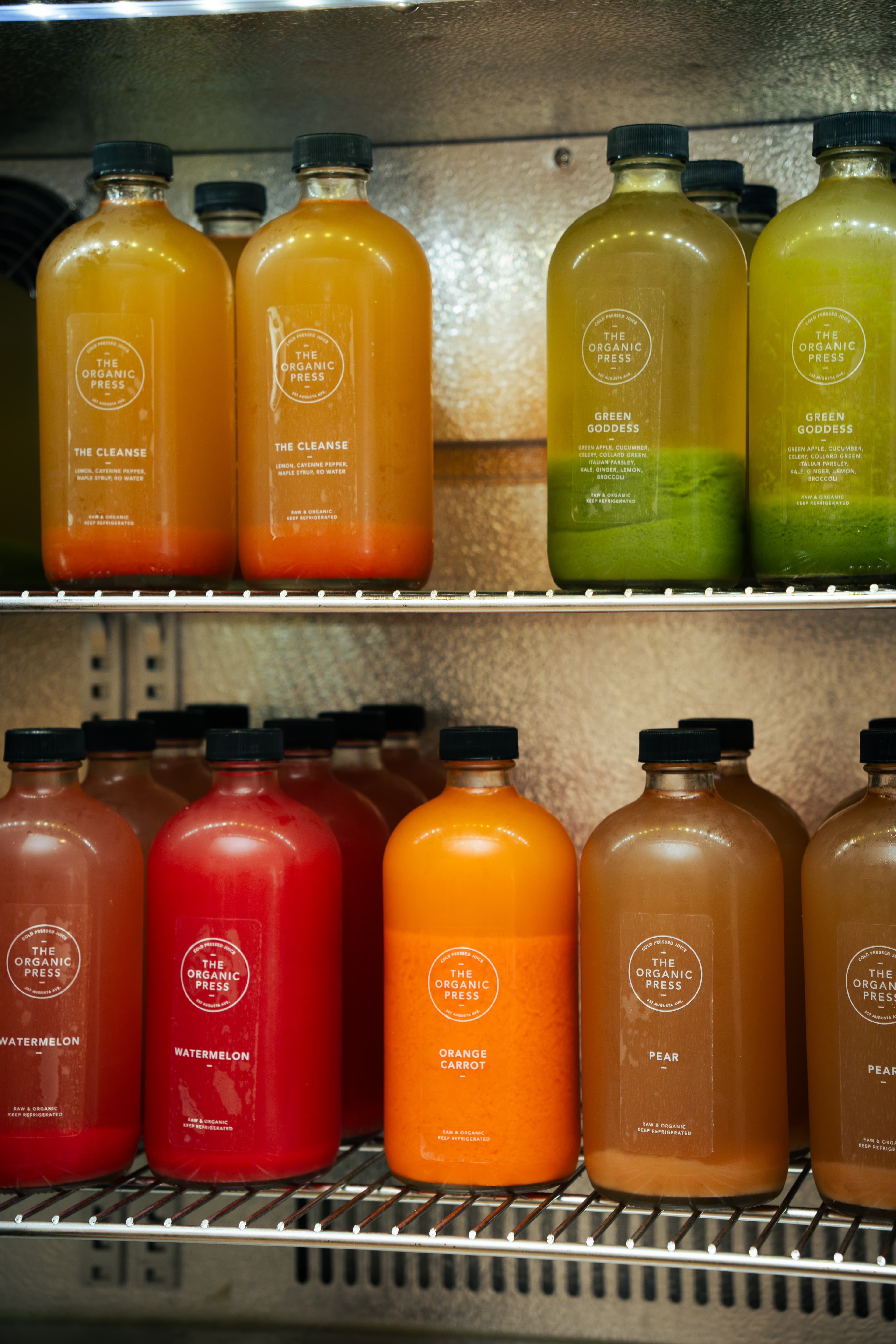 Colorful cold-pressed juice bottles arranged inside a refrigerator